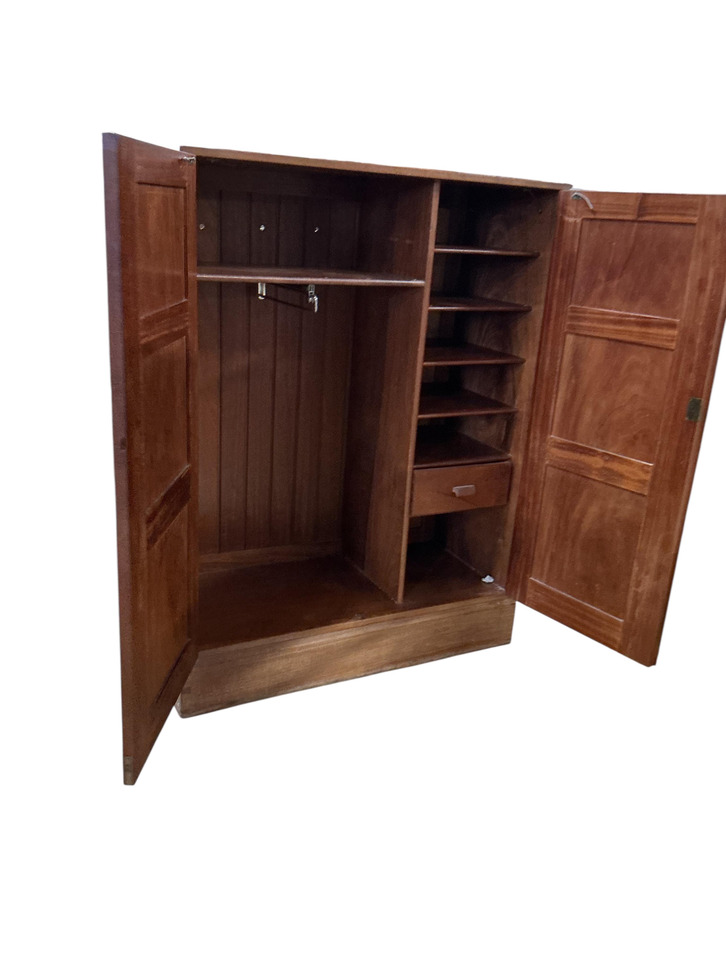 Manner of Gordon Russell, a mid century teak two door compactum, width 99cm, depth 44cm, height 130cm